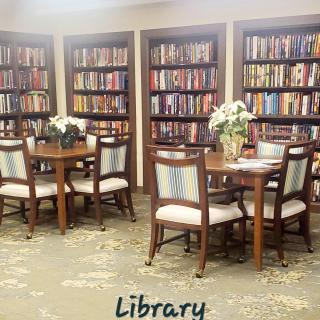 A cozy library corner with bookshelves, tables, and chairs for reading.