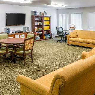 A cozy living room with sofas, a television, and a bookshelf.