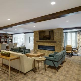 A modern living room with comfortable seating and a stone fireplace.