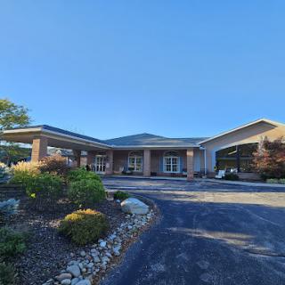 A modern entrance to a well-designed building surrounded by landscaped greenery.
