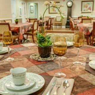 An elegantly set dining table with a decorative centerpiece in a cozy dining room.
