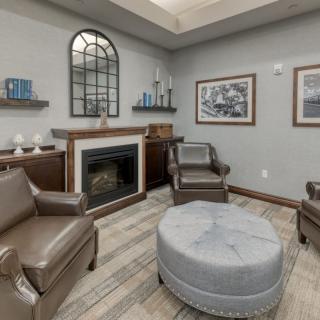 A cozy living room with a fireplace, comfortable seating, and elegant decor.