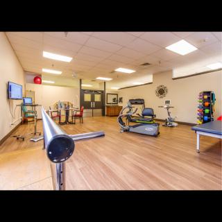 A spacious rehabilitation gym equipped for physical therapy and exercise.