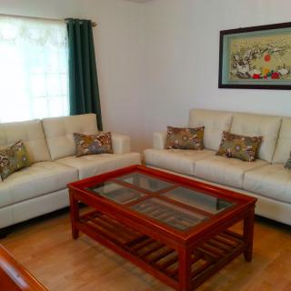 A cozy living room with two cream-colored sofas and a wooden coffee table.