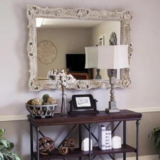 A stylish console table with a decorative lamp and ornate mirror, creating an elegant entryway display.