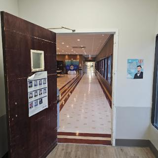 A view through an open door leading into a well-lit corridor.
