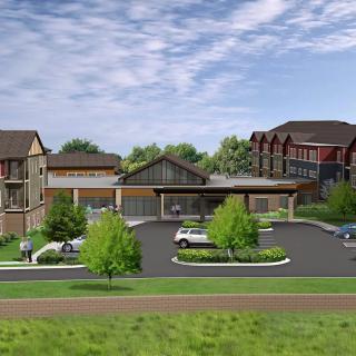 A suburban building complex with a parking lot and landscaped surroundings.