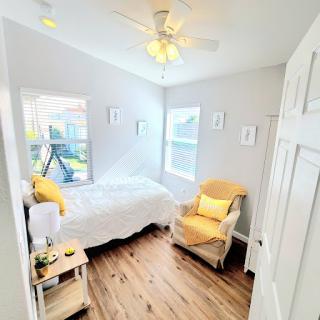 A bright and cozy bedroom featuring modern decor and ample natural light.