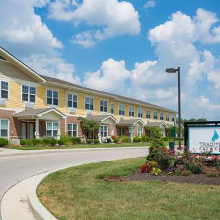 A residential building with a well-maintained landscape and a clear blue sky in the background.