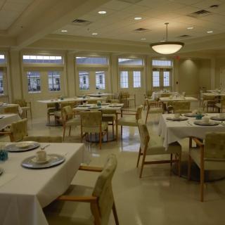An elegant dining room with neatly arranged tables and chairs, ready for guests.