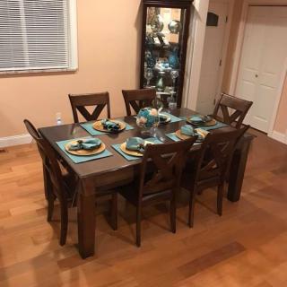 A neatly set dining table with chairs in a cozy dining room.