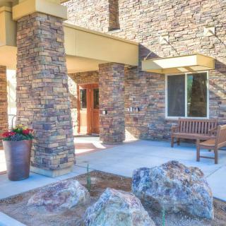An entrance featuring a stone facade with a bench and decorative rocks.