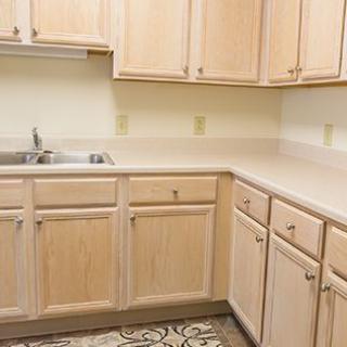 A kitchen with light wood cabinets and a clean countertop.