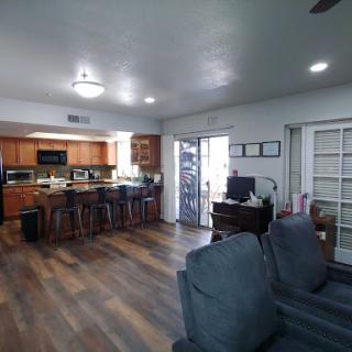 A spacious open-concept kitchen and living room area showcasing modern design elements and wooden flooring.