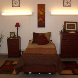A modern bedroom featuring a single bed with matching nightstands and stylish wall art.
