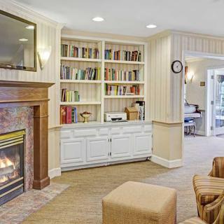 A cozy living room with a fireplace and built-in bookshelf.