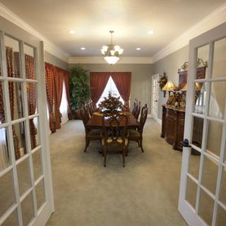 A traditional dining room with elegant furnishings and French doors.