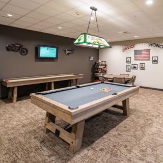 A cozy game room featuring a billiards table and shuffleboard.