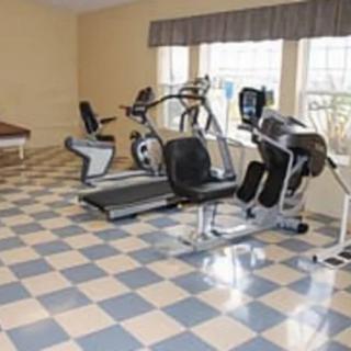 An indoor gym with exercise equipment, featuring stationary bikes and elliptical machines.