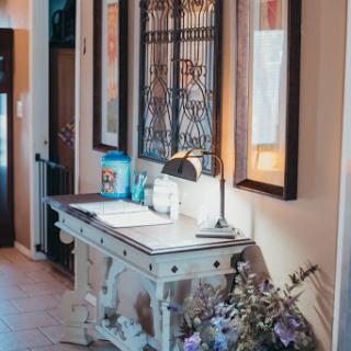 A beautifully decorated entryway featuring a stylish table, framed artwork, and soft natural lighting.