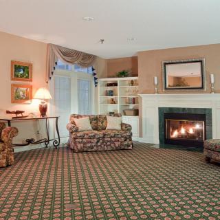 A cozy living room with a fireplace and floral patterned furniture.