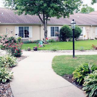 A neatly landscaped garden with a winding pathway leading to a house.