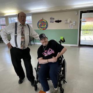 A moment shared between a caregiver and an individual in a wheelchair, showcasing companionship and support.