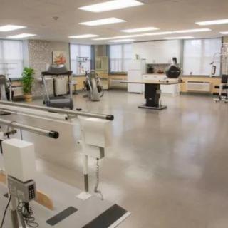 A spacious rehabilitation center equipped with various exercise machines and tools.