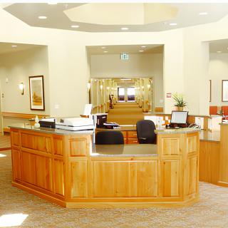A bright and welcoming reception area with a central desk and office furnishings.