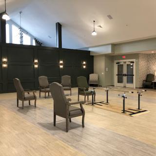 A spacious lounge area featuring modern chairs and tables, illuminated by natural light.