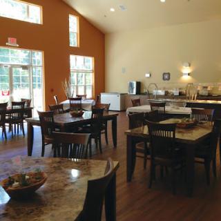 A spacious dining area with modern furniture and large windows allowing plenty of natural light.