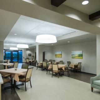 A modern dining area with neatly arranged tables and chairs, complemented by elegant lighting and decor.