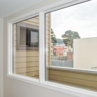 A view from an indoor window overlooking neighboring buildings and trees.