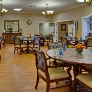 An elegantly arranged dining room with multiple tables and chairs, set for a meal.