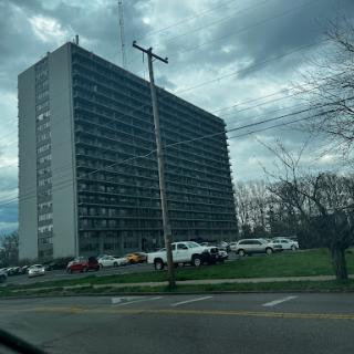 A tall residential building with a cloudy sky in the background.