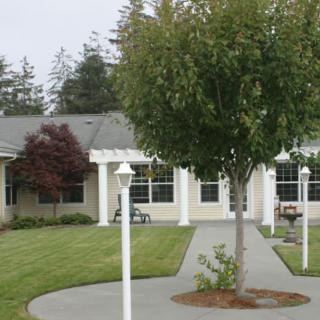 A house with a well-maintained yard featuring trees and a pathway.