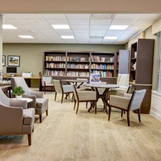 A cozy library with comfortable seating and bookshelves filled with books.