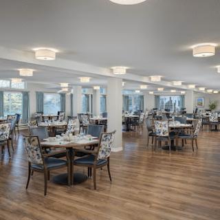 A spacious and elegantly designed dining area featuring wooden floors and modern furnishings.
