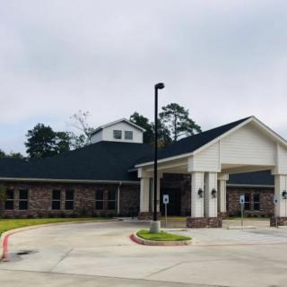 A building with a covered entrance and driveway on an overcast day.