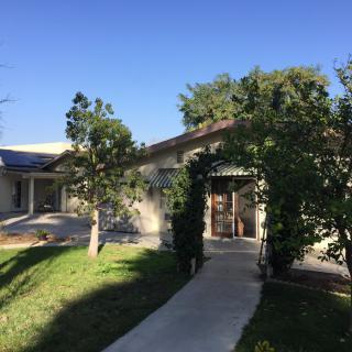A suburban house with a driveway and surrounding trees on a sunny day.
