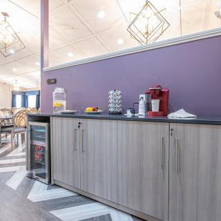 A modern kitchen counter with a beverage station, featuring a coffee machine and juice dispenser.