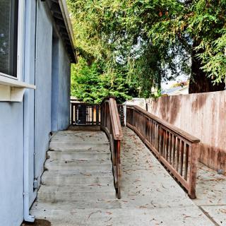 An outdoor accessibility ramp alongside a building, leading to an entrance.