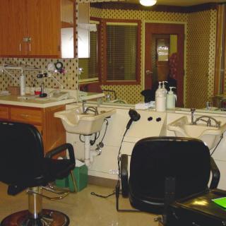 Interior of a hair salon with chairs, mirrors, and washing sinks.