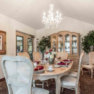 An elegant dining room with a chandelier, featuring a beautifully set table and classic furniture.