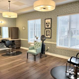 A well-appointed hair salon interior with stylish chairs and mirrors.