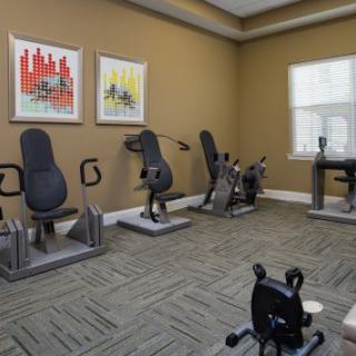 A small gym with stationary bikes and exercise machines in a neatly arranged interior space.