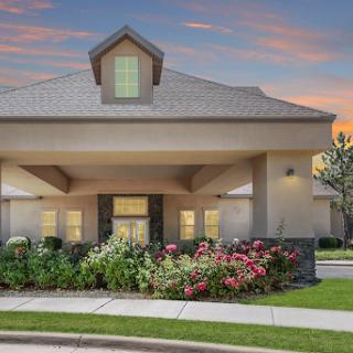 A welcoming residential building with lush landscaping at dusk.
