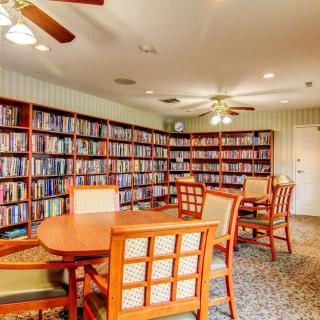 A cozy library room with bookshelves filled with books and tables for reading.