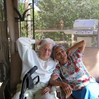 An elderly couple sitting together on a patio, enjoying a peaceful outdoor moment.