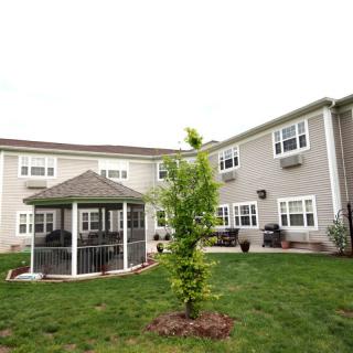 A view of a building with a gazebo and landscaped lawn.